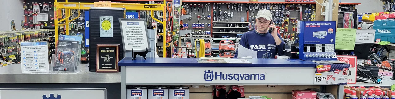 T & M Hardware and Rental Center, services counter with a man behind the desk answering a phone