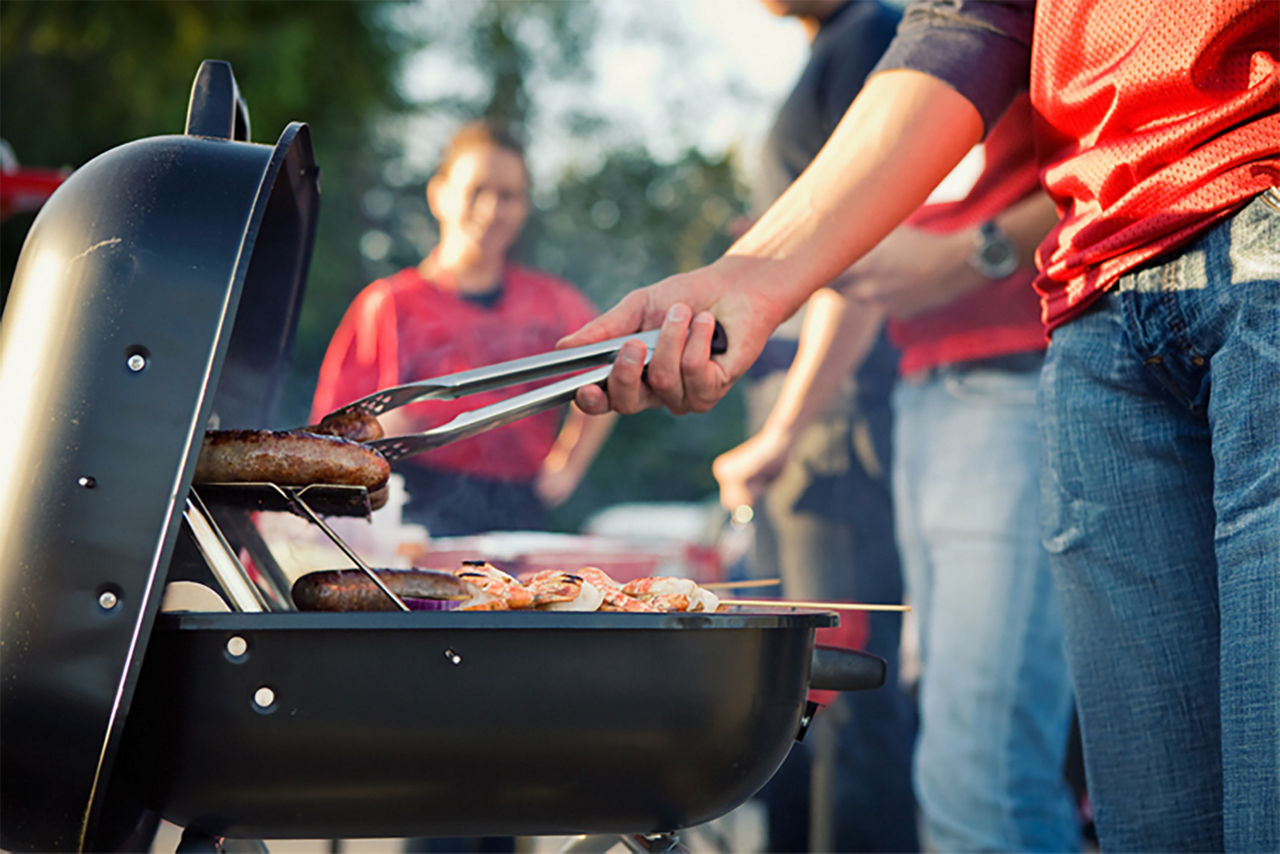 Close up of someone grilling at their tailgate section