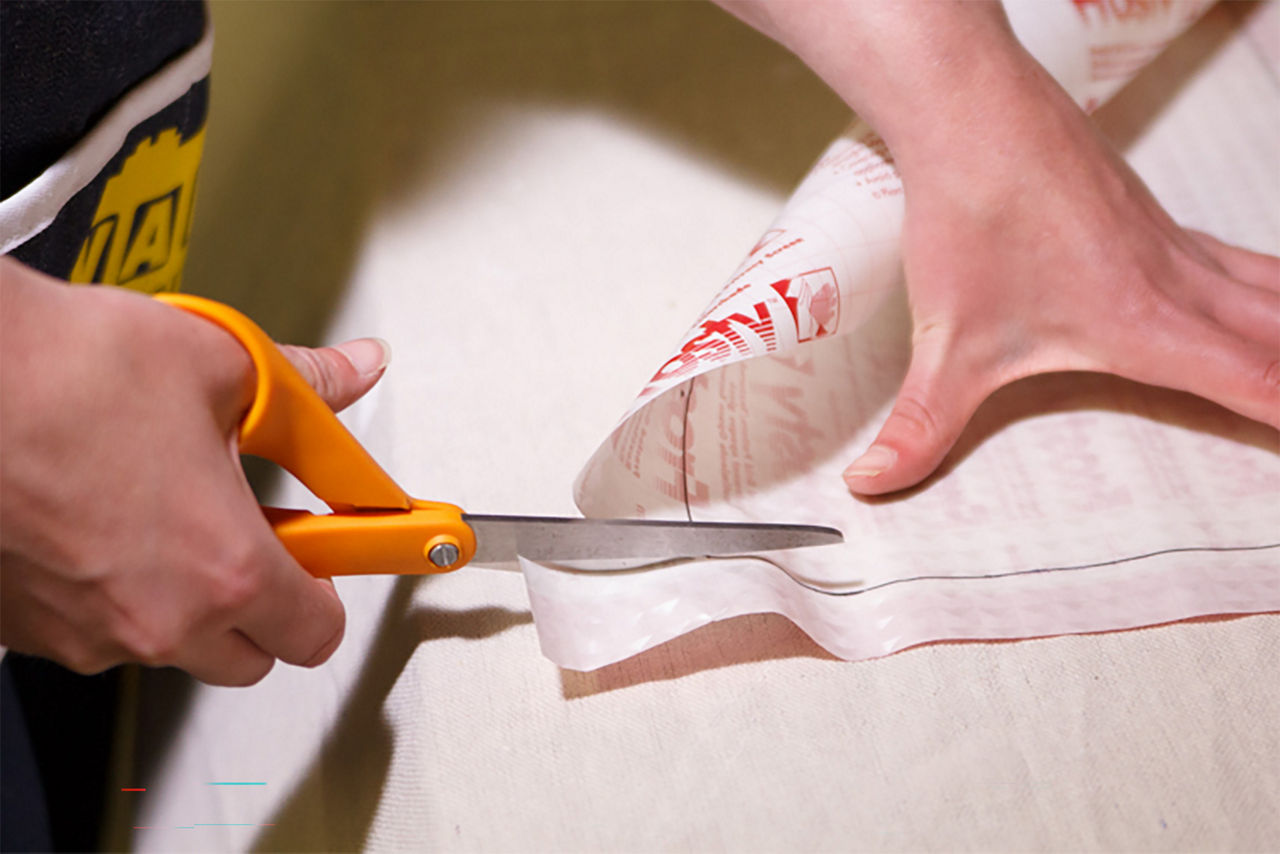 Person cutting the con-tact paper to fit the glass window pane quadrants