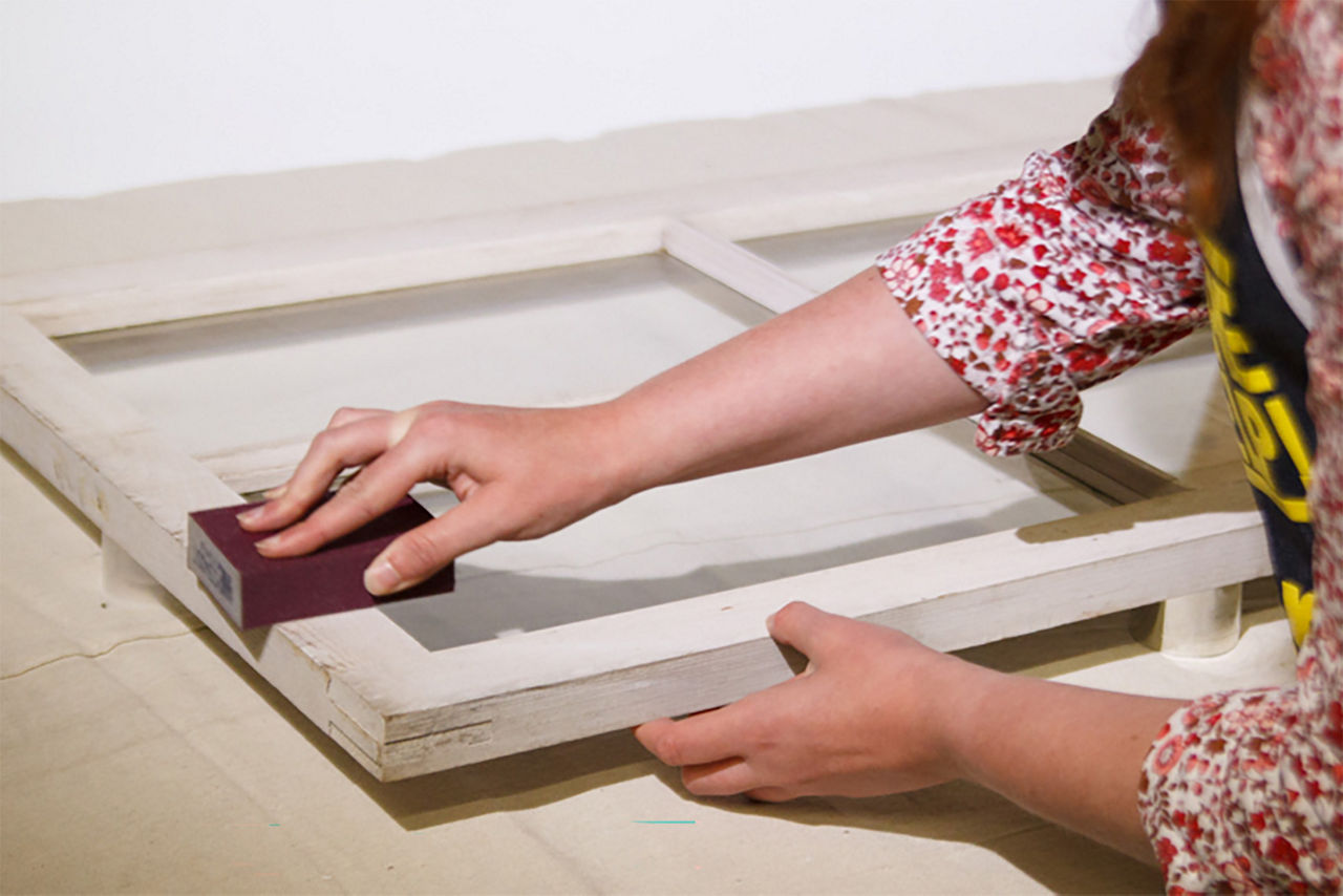 Person sanding the frame for the window planner