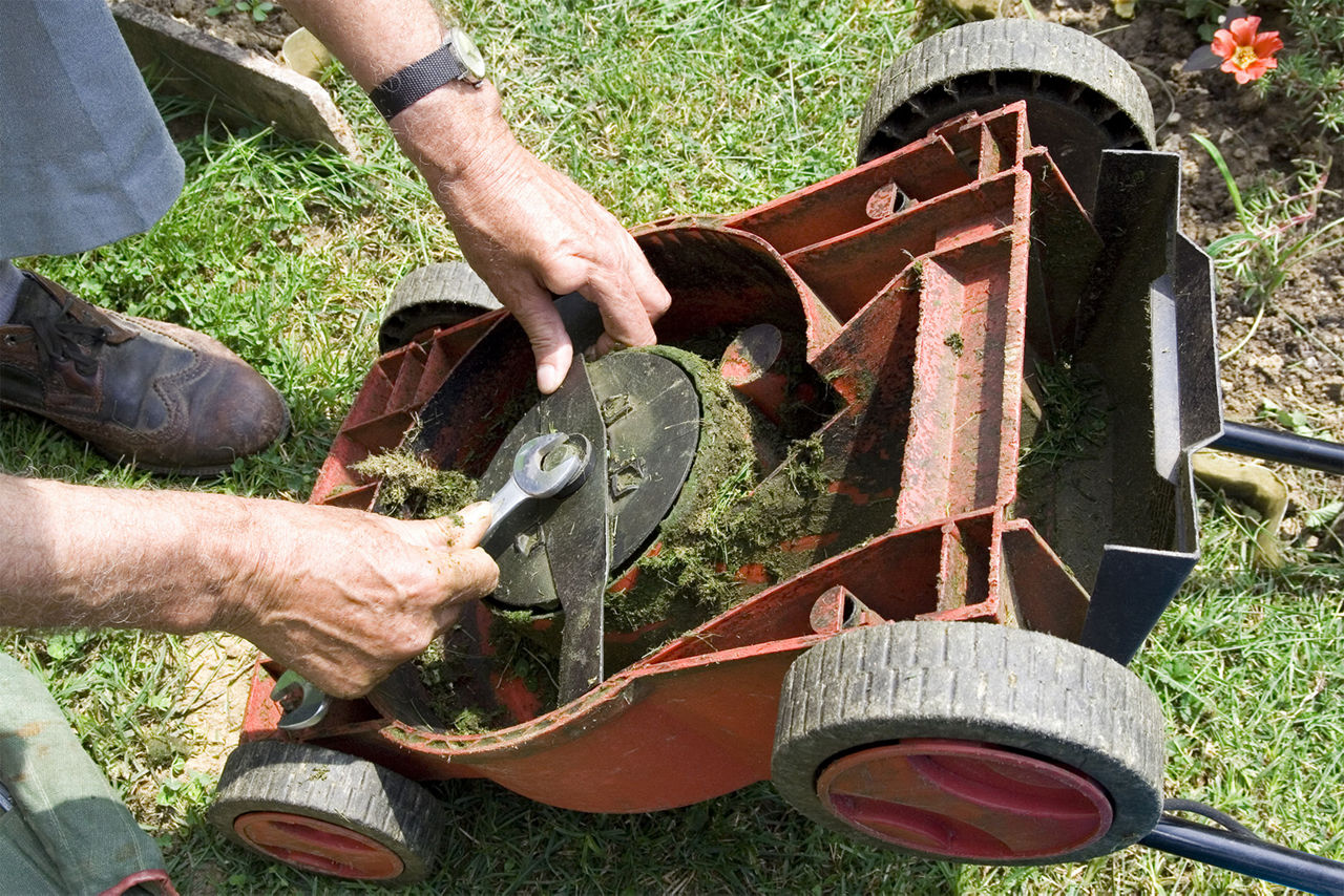 Person working on the lawnmower blades