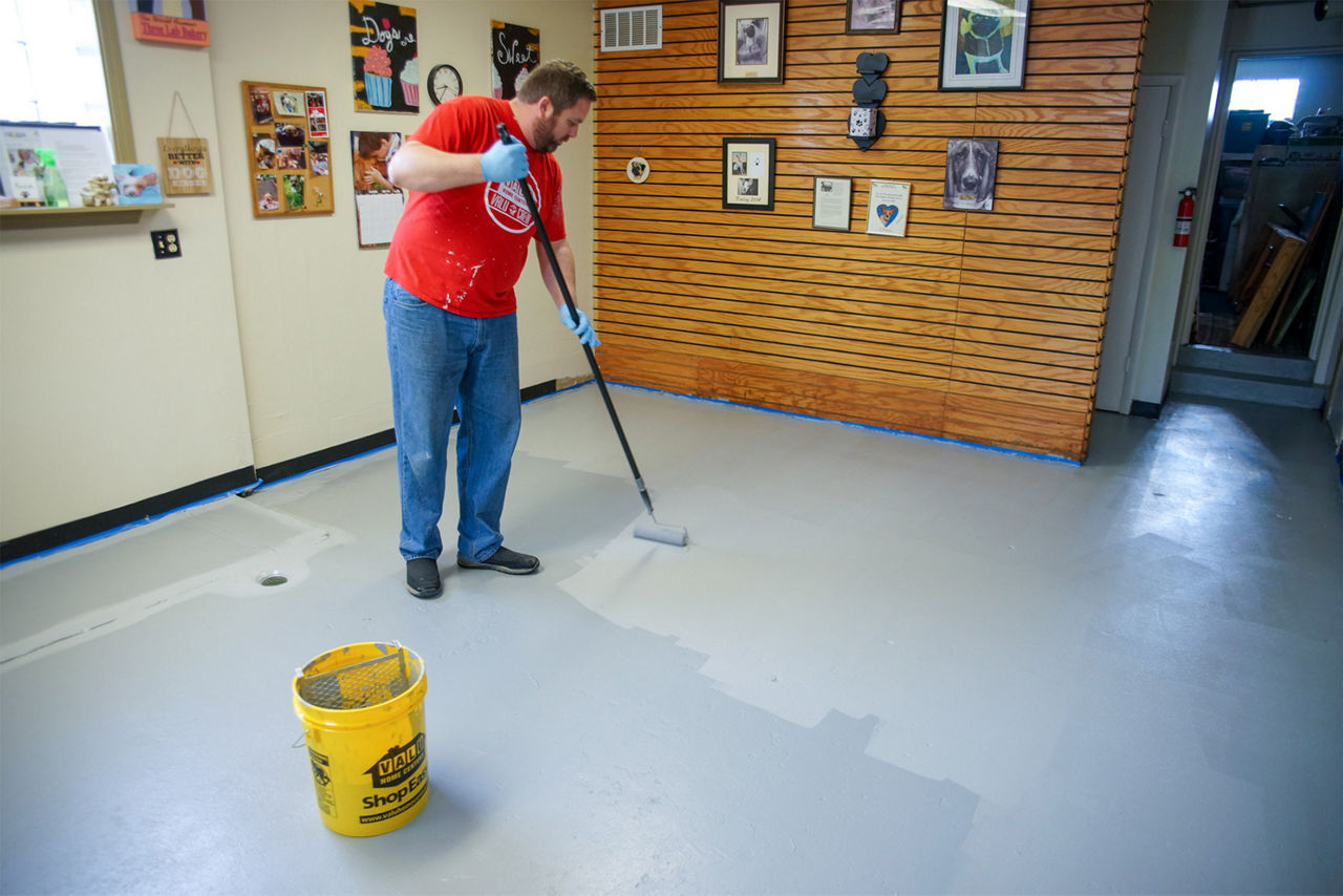 Guy paints on the epoxy floor paint