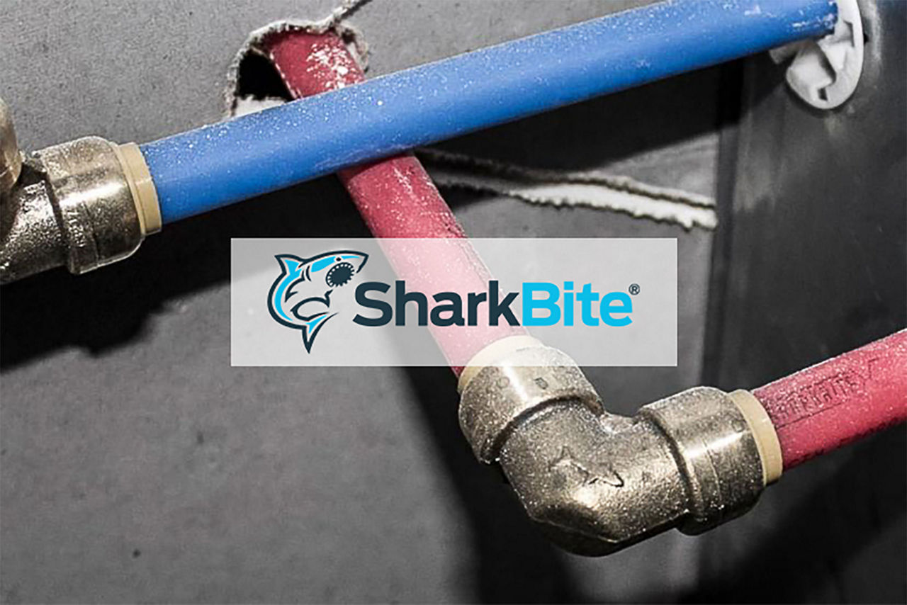 Sharkbite logo over pipes