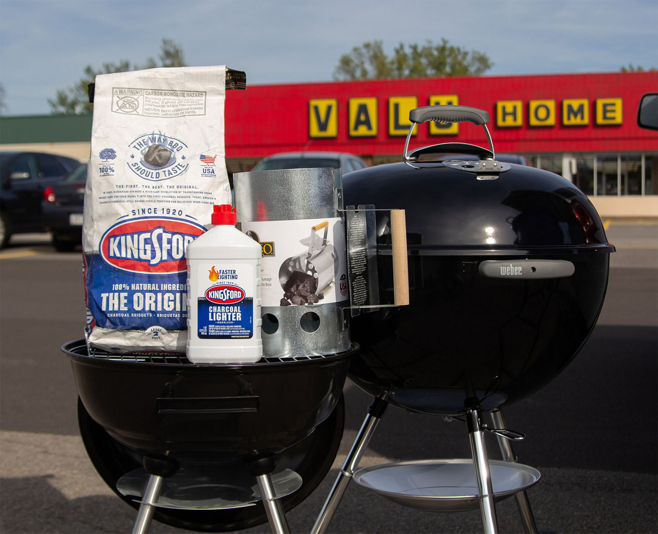 Close up grill and charcoal materials in front of a Valu Home Center