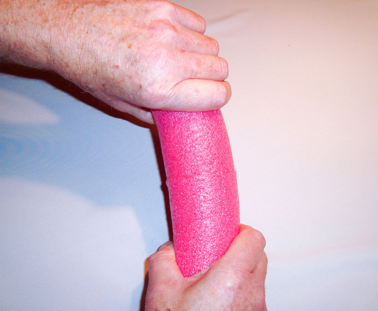 Holding the pool noodle ends together as the glue dries