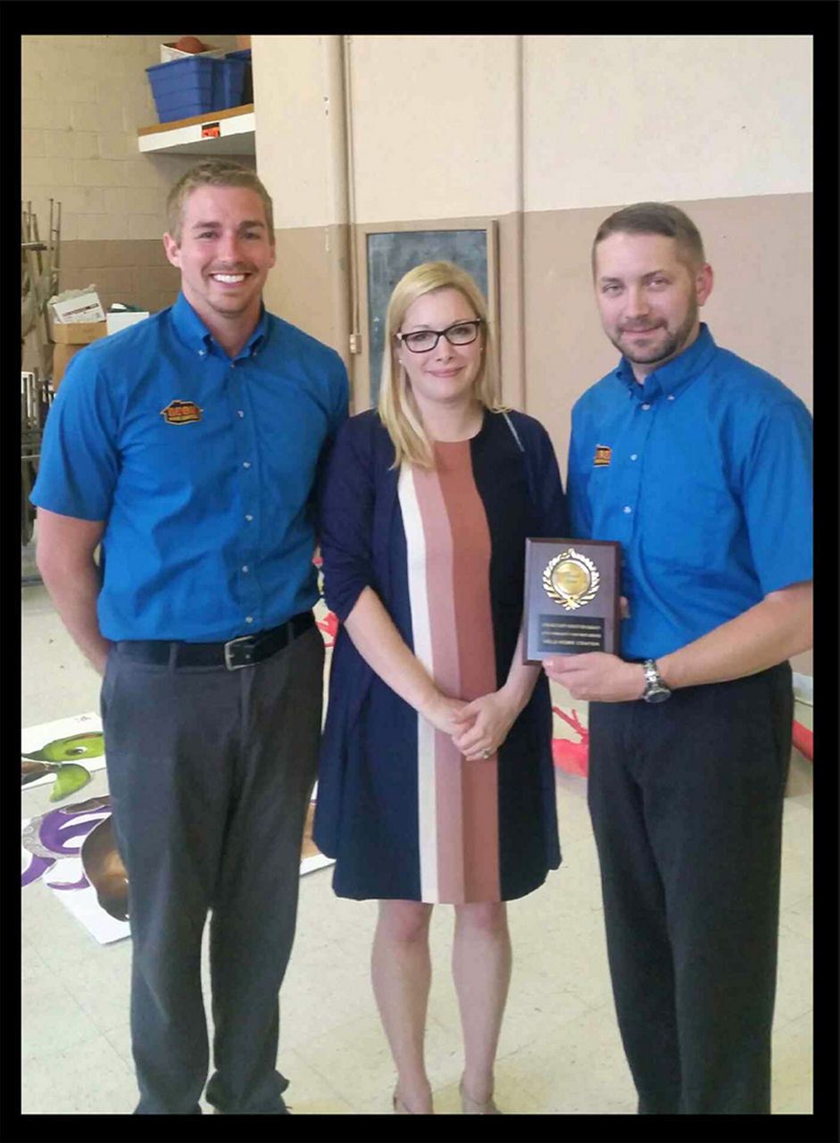 Award winners group photo with the plaque and a black border