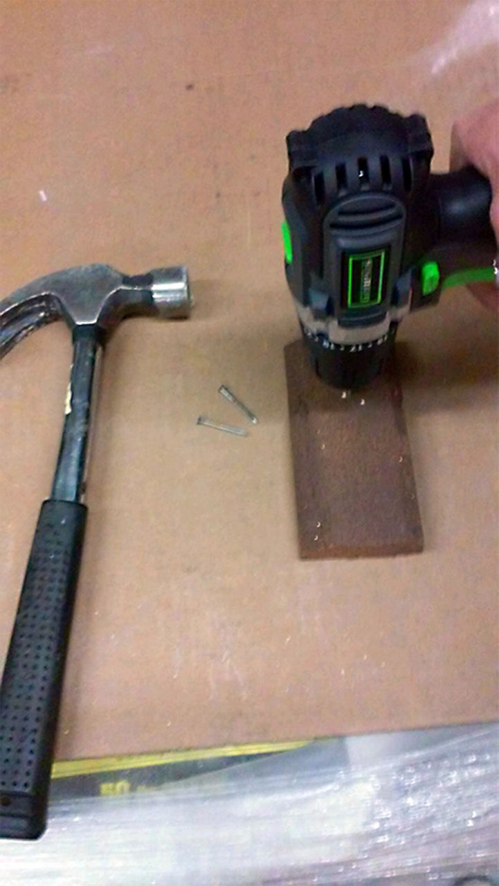 Person building the tree trunk with a hammer and drill