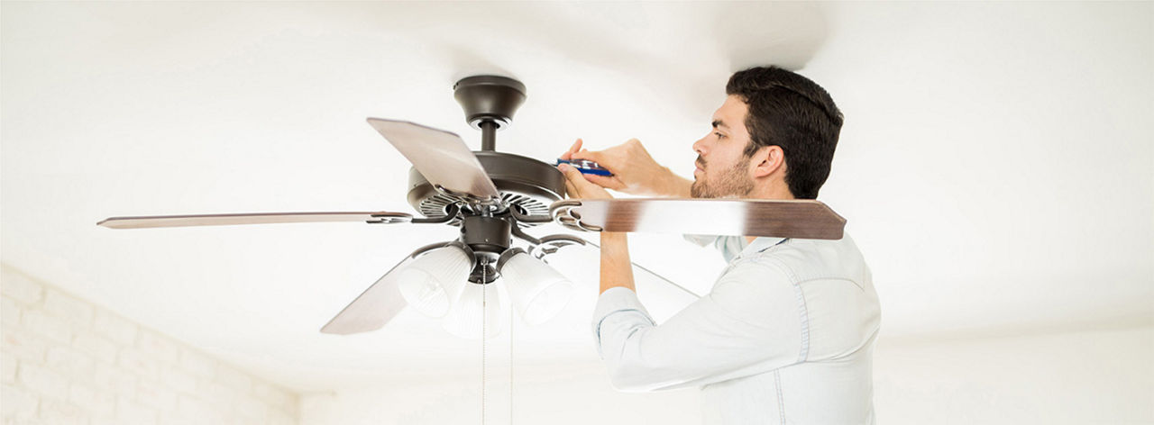 A guy working on fixing his ceiling fan