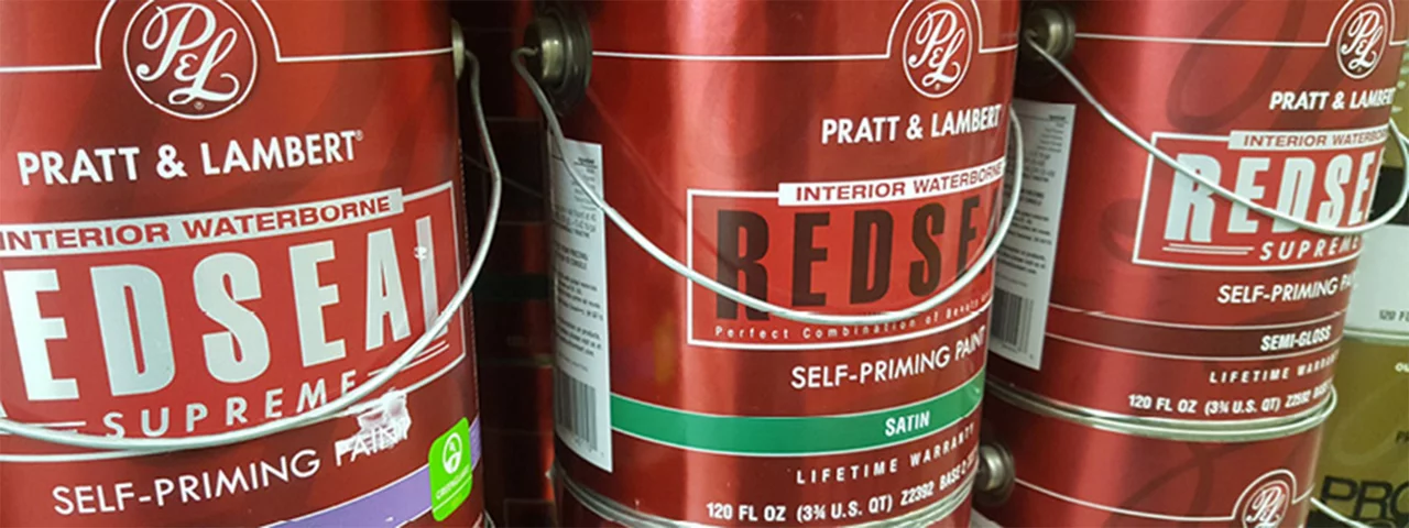 close up image of three red pratt and lambert gallon sized paint cans