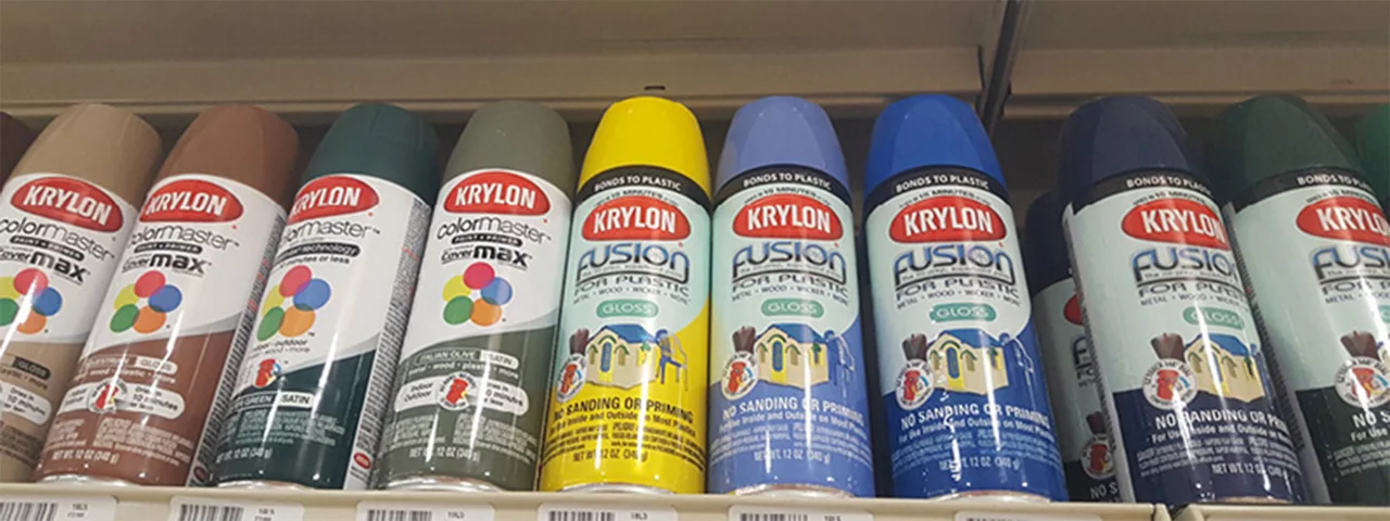 A bottom up view of a store shelf with cans of Krylon spray paint