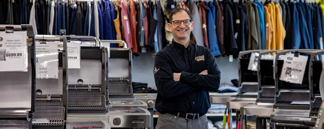 Store associate standing by Weber grills