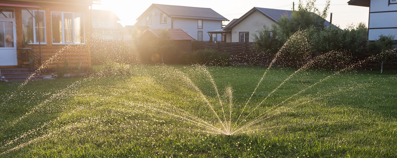 Sprinkler spraying water in all directions to cover yard