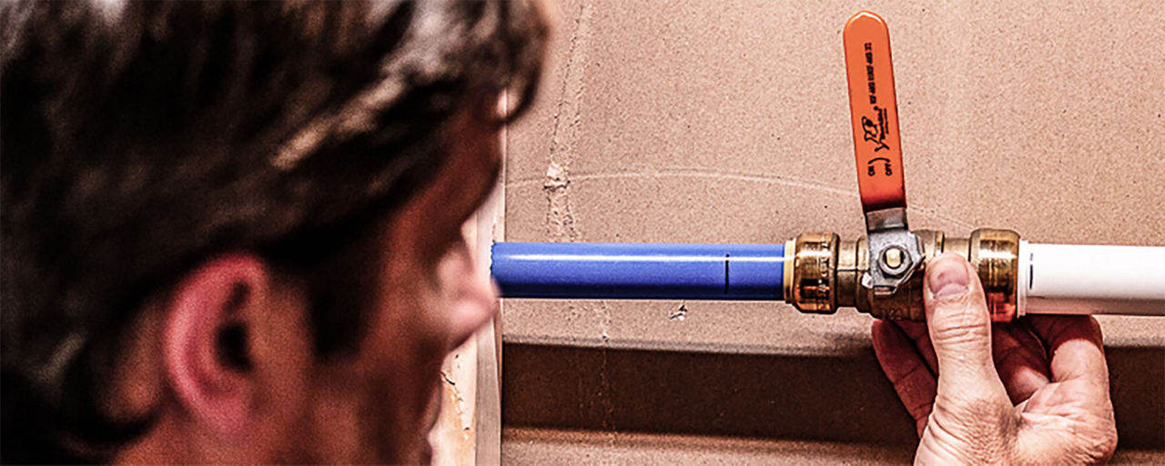 Man inspecting pipes up real close