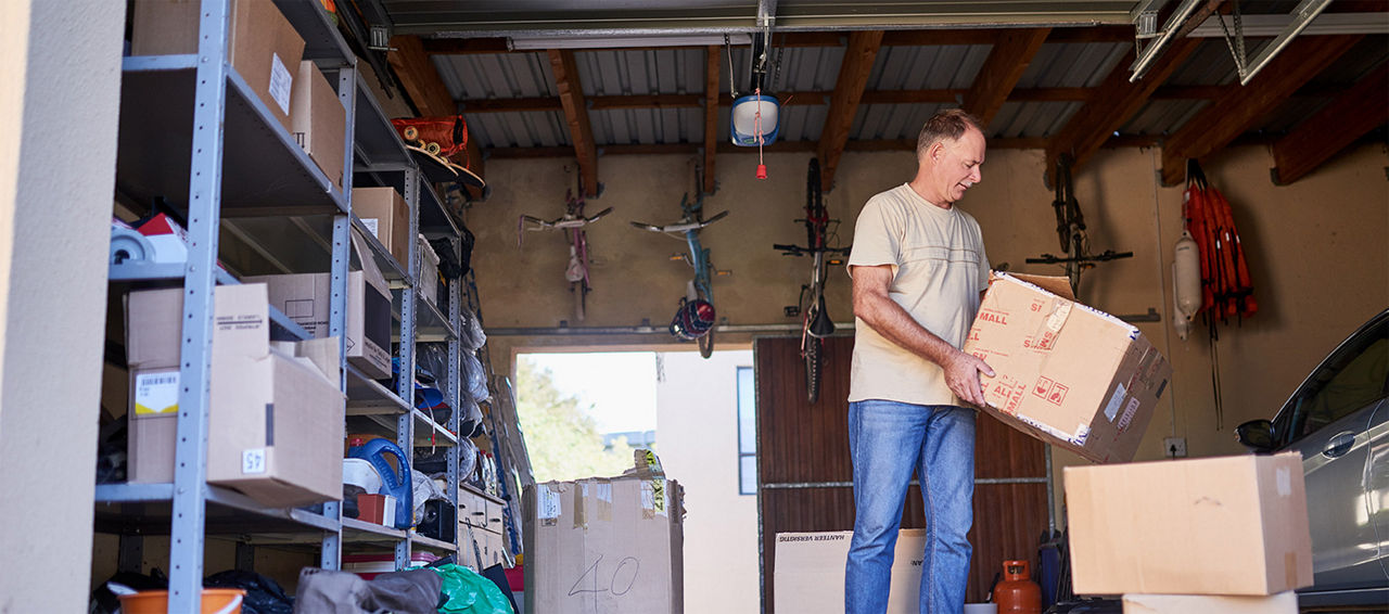 Man moving boxes to clean his garage