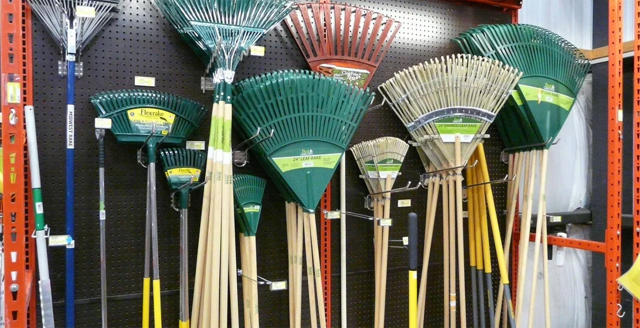 Multiple garden rakes hanging on a pegboard store display