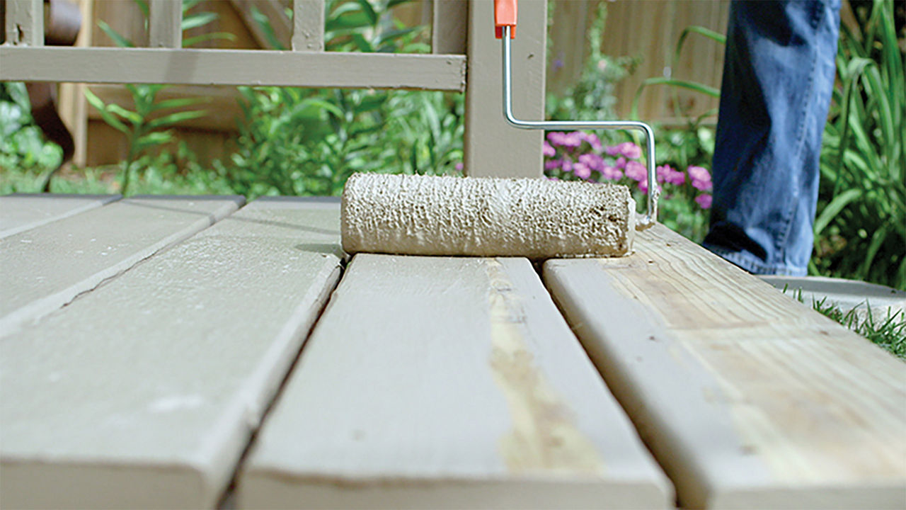 Image of applying a second coat of the deck coat with the paint roller coming towards you