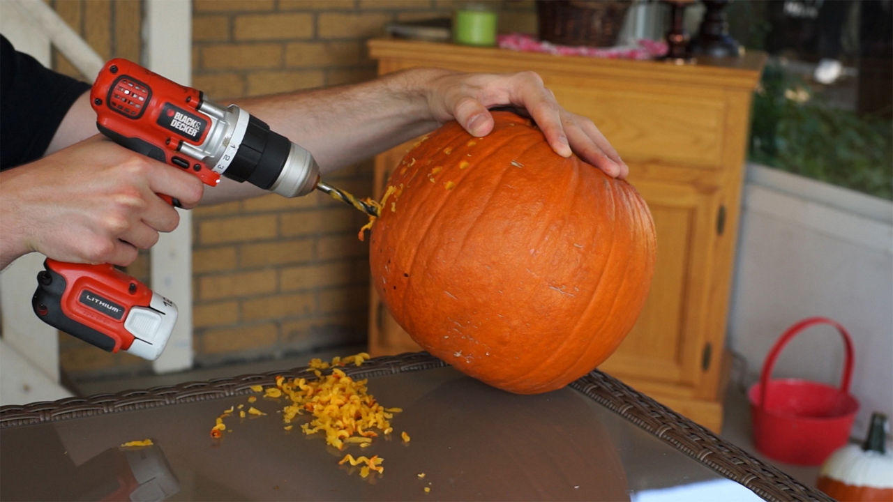 Person using the drill on the pumpkin