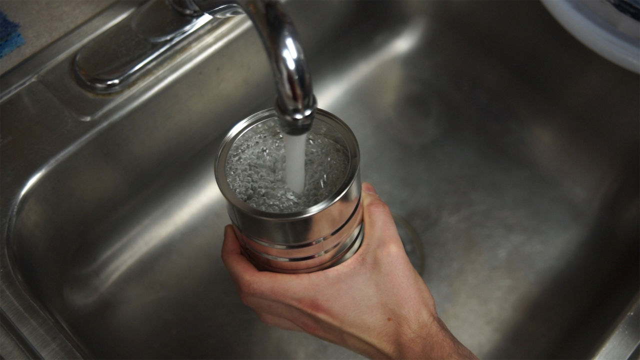 Person filling the can with water to put it in the freezer