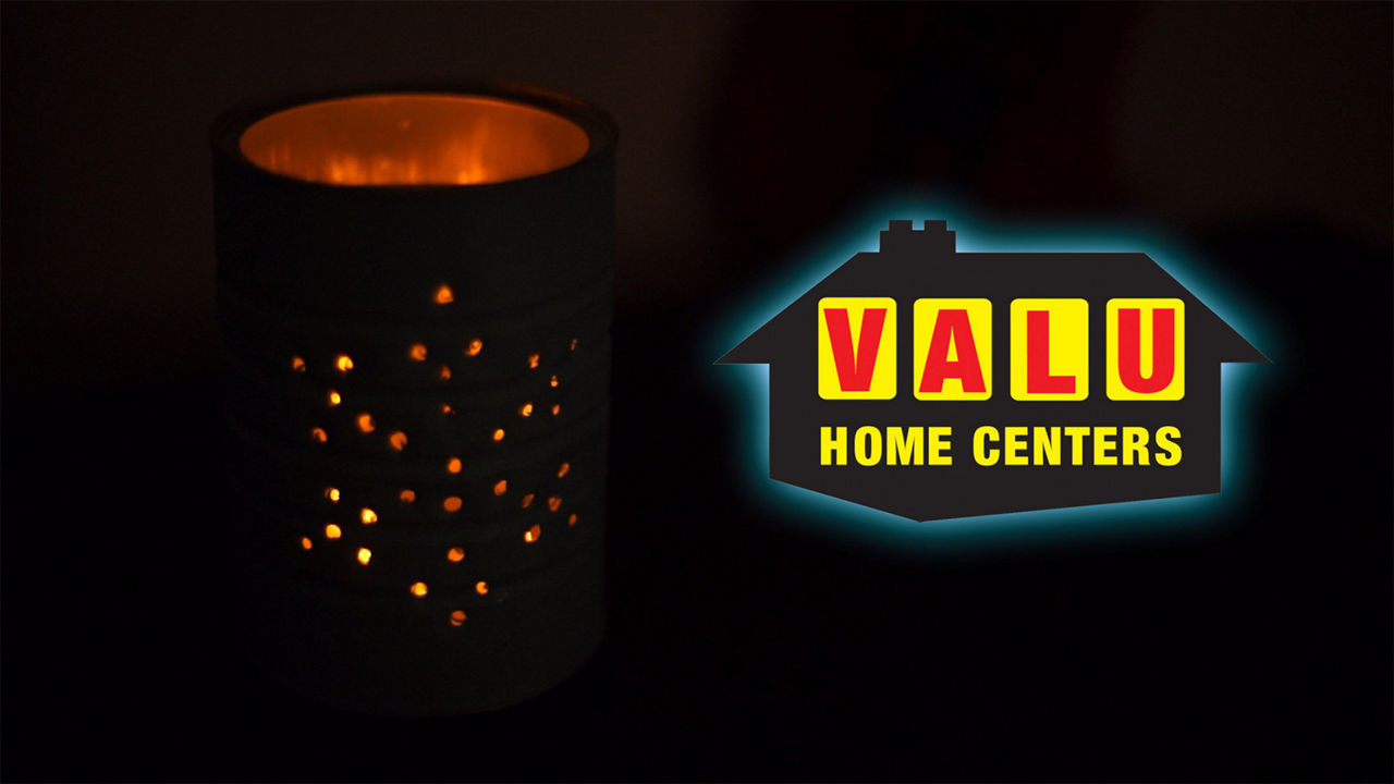 Lit up holiday tin can next to a Valu Home Center logo