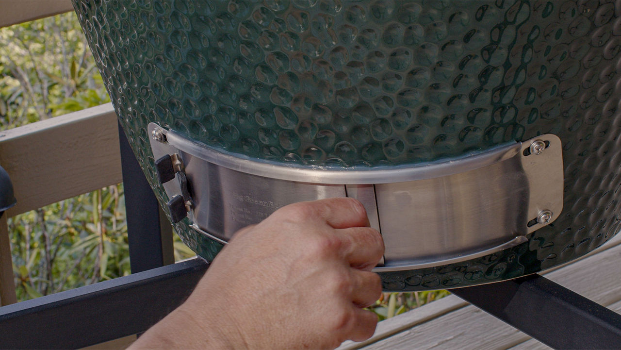 The bottom stainless steel draft door of a Big Green Egg