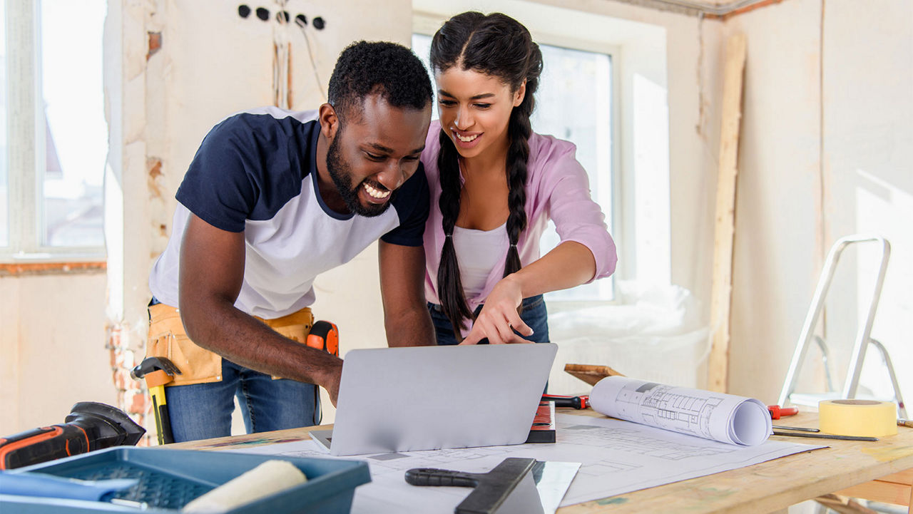 A couple planning out their home rennovation on a laptop