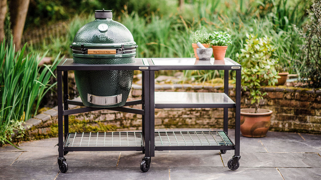 A Big Green Egg sitting in a nest on a patio