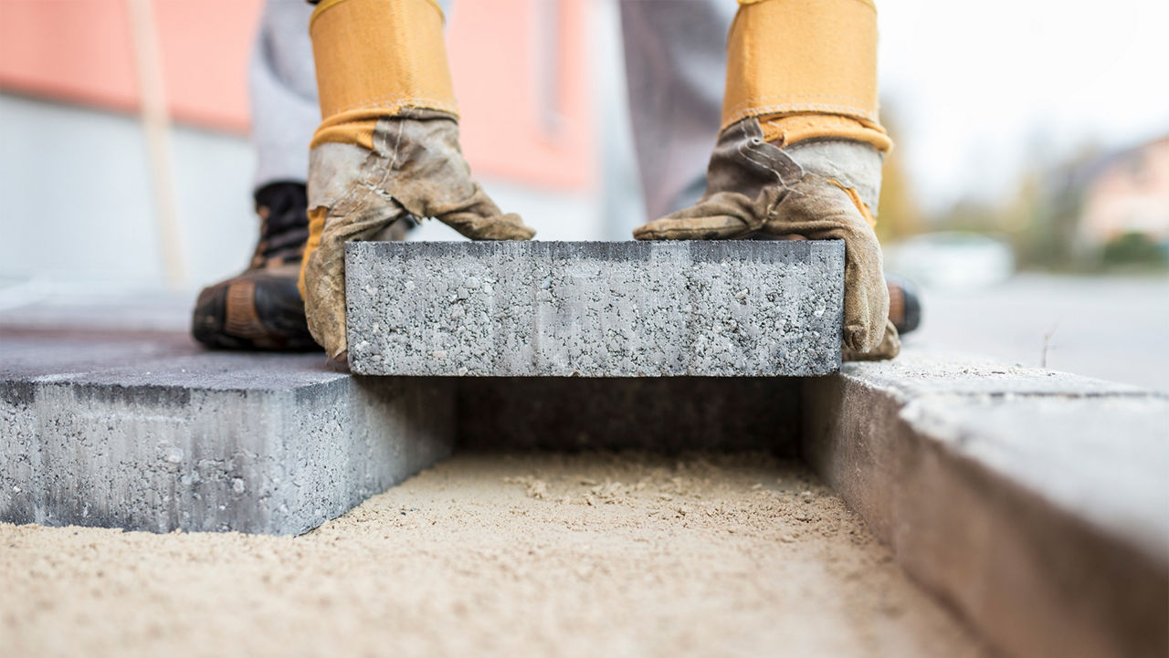 Man carefully laying a paver down