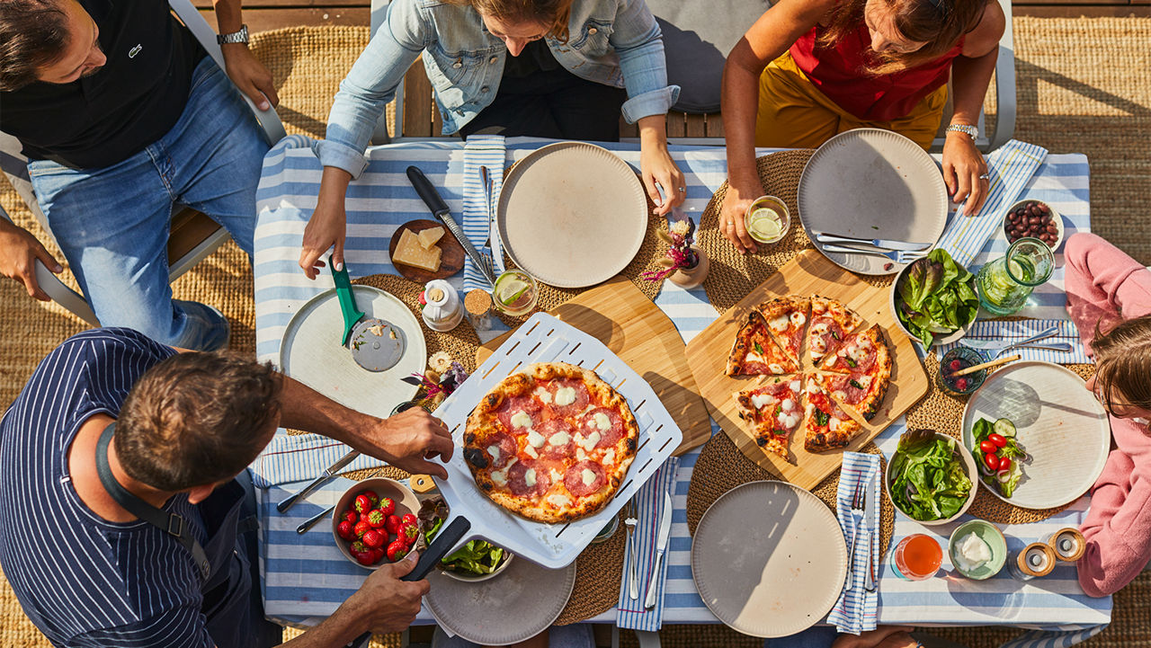 Ooni Pizza Oven - Topview of a family gathered around a table to enjoy a meal