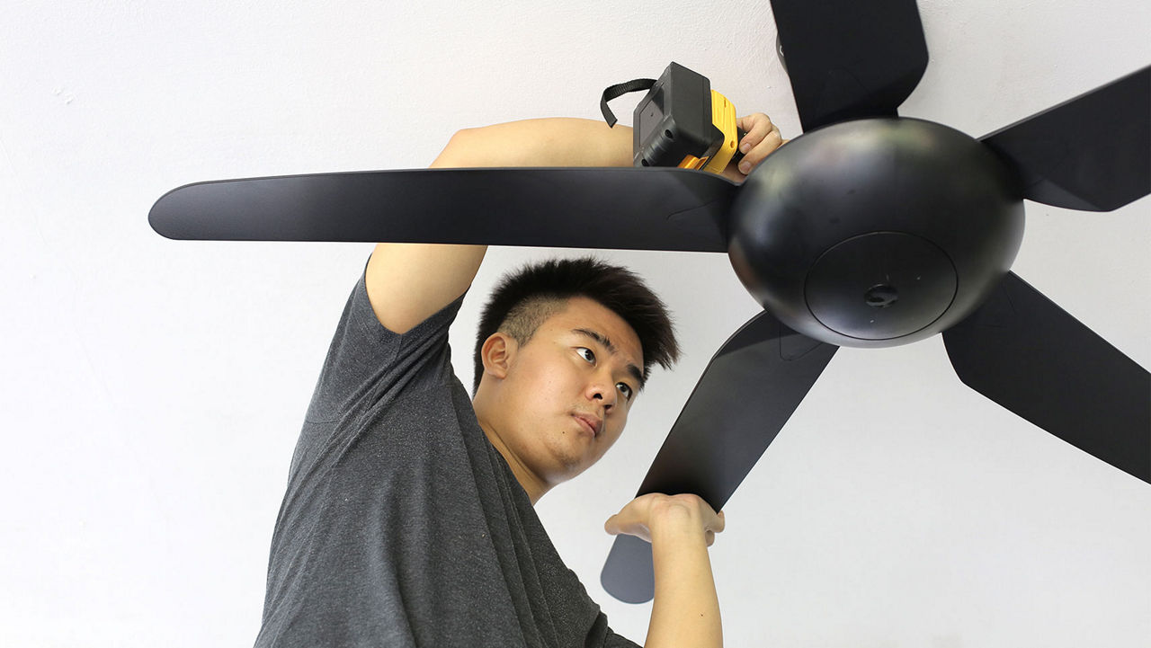 A man removing a ceiling fan