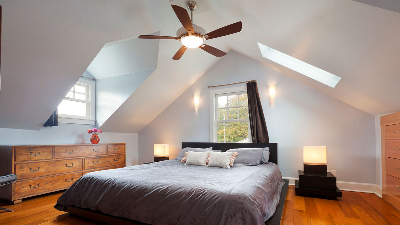 Ceiling fan in a bedroom hanging over a bed