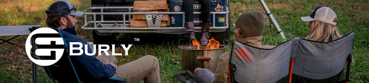 Burly Grills. Three people sitting around a fire pit while camping
