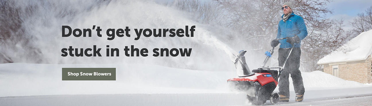 Don't get yourself stuck in the snow - Man pushing a snowblower to clear a driveway