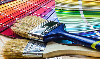 Different color swatches laid out on a table with two paint brushes beside each other