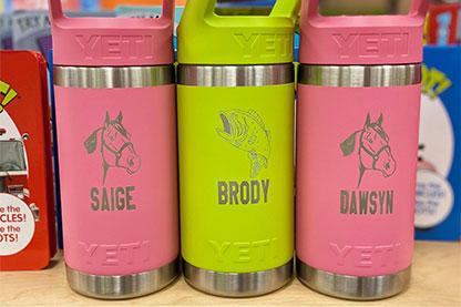 Three YEIT Water bottles two green and one pink with engravings