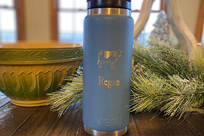 Light Blue YETI Tumbler with a cow and Regan engraved on it 
