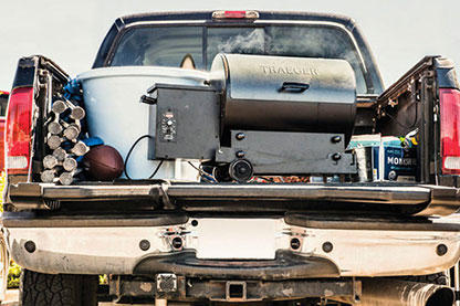 A Traeger grill on the tailgate of a pickup truck