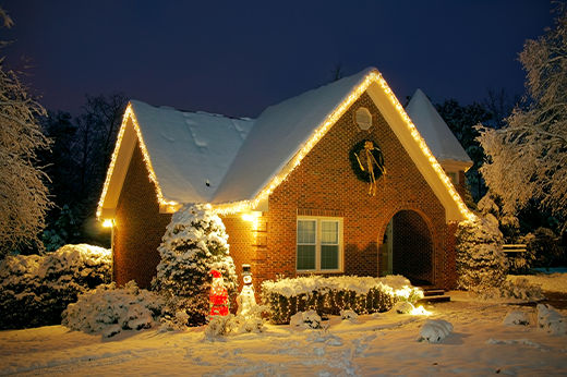 Christmas Lights lit up on a snowy house