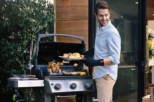 Man using Weber grill to cook dinner for his family