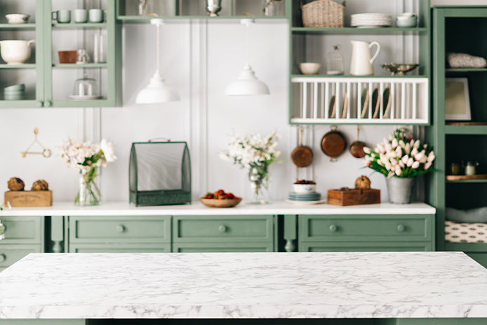 Marbled countertop with green cabinetry in the background