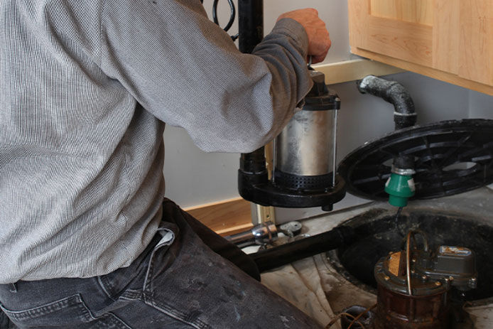 Man swapping out sump pumps