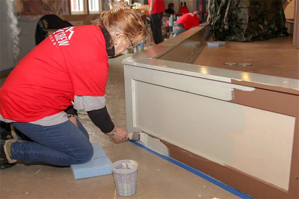 Valu member helping paint the Herschell Carrousel Factory Museum