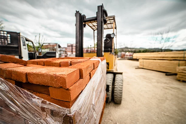 Forklift moving a pallet of bricks