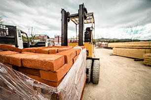 Forklift with a pallet of red pavement bricks