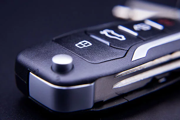 A close-up of a car key fob on a dark surface