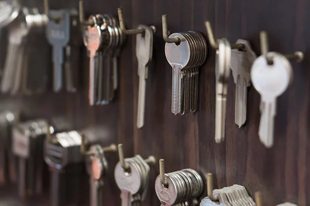 Blank silver keys hanging from hooks on a pegboard at a hardware store