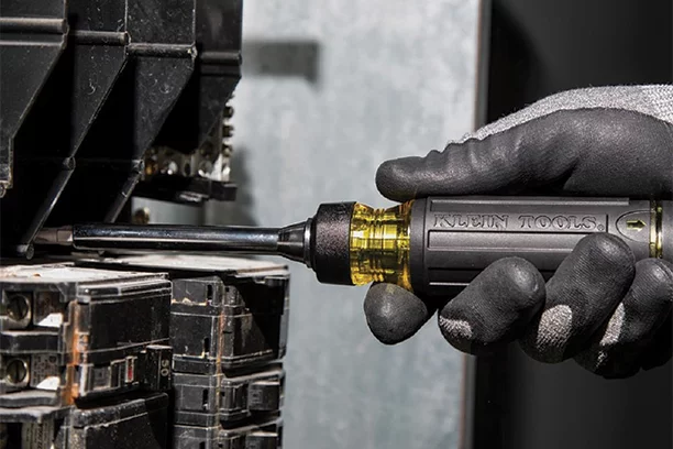 Man using a Klein Screwdriver to work on an circuit breaker