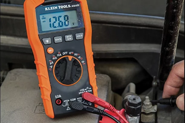 Klein electric tester being used to check a car battery
