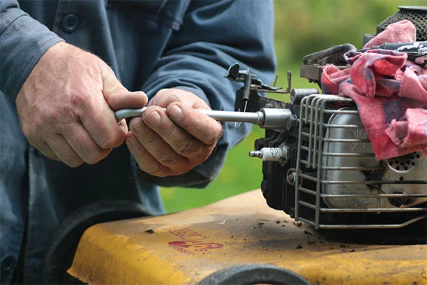 man repairing a small engine