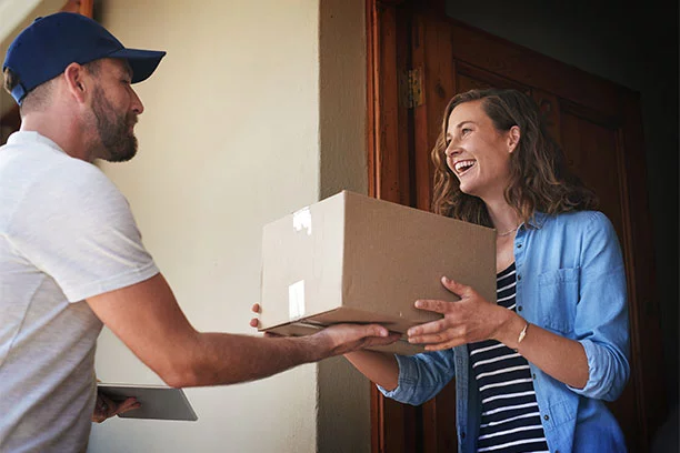 Shot of a courier making a delivery to a customer at her home