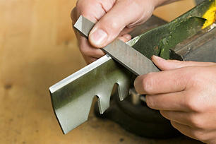 Person sharpening a mower blade